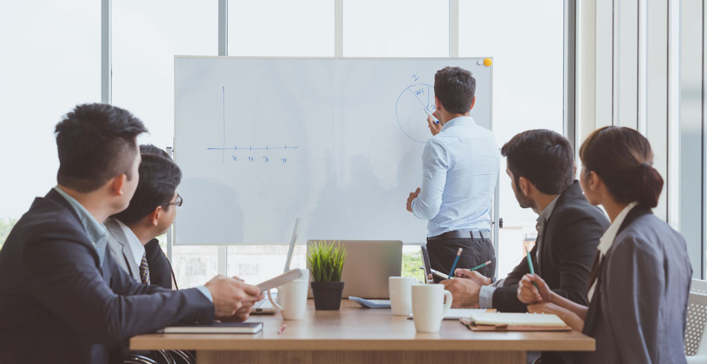 Consultant écrivant au feutre sur tableau magnétique en salle de réunion
